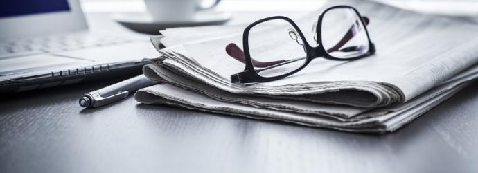 Pair of glasses resting on a newspaper