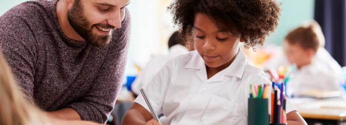 A male teacher with primary school pupil