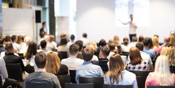 Male delivering a training session in front of an audience