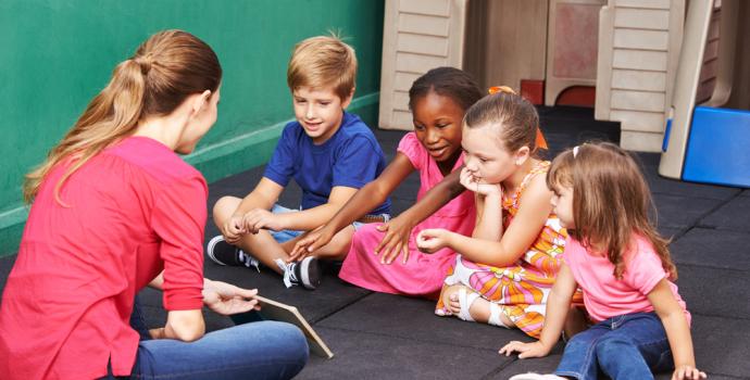 Group of EY Children reading a book with their education practitioner