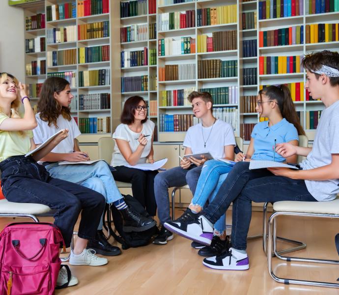 Six university students sitting in a circle in a library