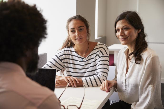 male teacher speaking with a parent of a secondary school age girl